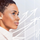 Confident professional woman looking ahead with upward arrows symbolizing growth and success, with abstract digital interface elements in the background.