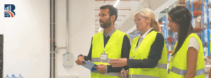 Team of auditors in high-visibility vests conducting a warehouse inspection – business excellence, quality control, and operational assessment.