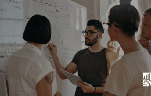 Team in a meeting discussing strategies at a whiteboard – leadership, planning, and innovation at BARE International.