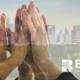 Hands coming together over a city skyline symbolizing ESG-driven customer experience, sustainability, and responsible business growth.
