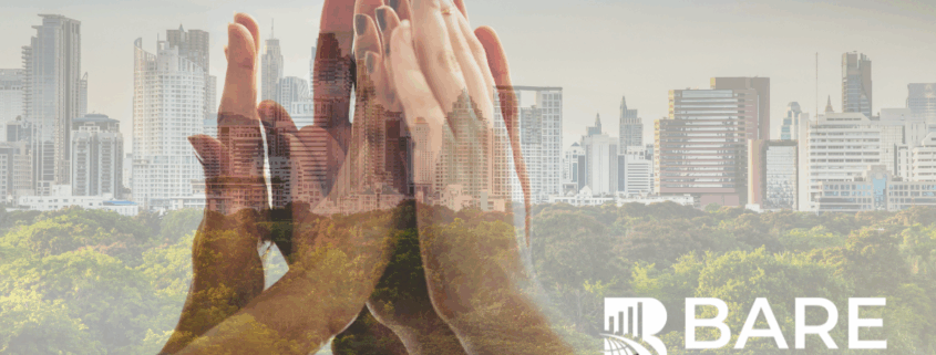 Hands coming together over a city skyline symbolizing ESG-driven customer experience, sustainability, and responsible business growth.