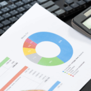 Business professional reviewing customer experience budget charts and analytics while calculating 2026 CX investment priorities.