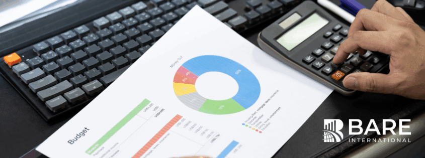 Business professional reviewing customer experience budget charts and analytics while calculating 2026 CX investment priorities.