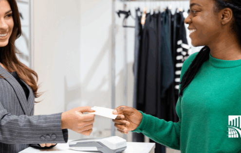 Retail associate assisting a customer at checkout, illustrating consistent in-store customer experience measured through monthly mystery shopping